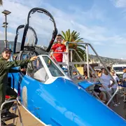 Enfant près d’un cockpit d’avion exposé sur le village aéronautique