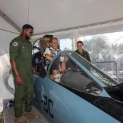 Visiteur installé dans un cockpit avec deux militaires de l’armée de l’Air